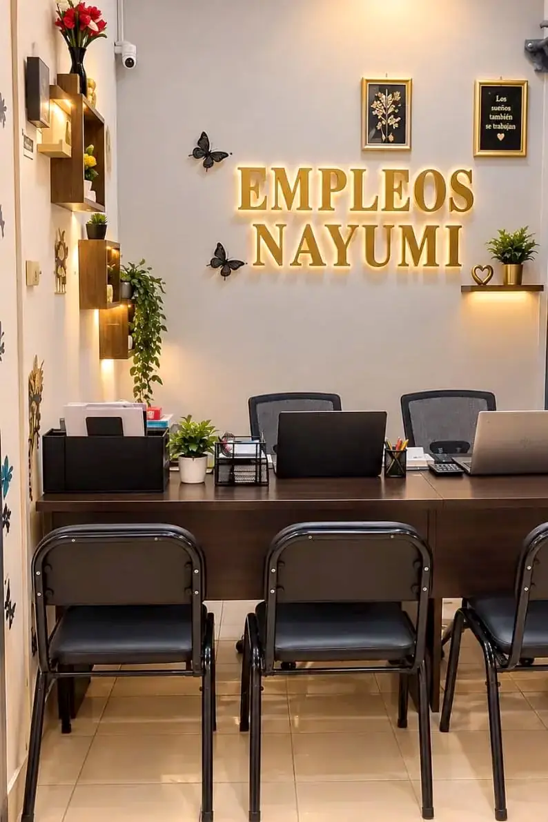 Oficina real de Empleos NAYUMI: recepción con escritorio de atención y letrero iluminado de la agencia